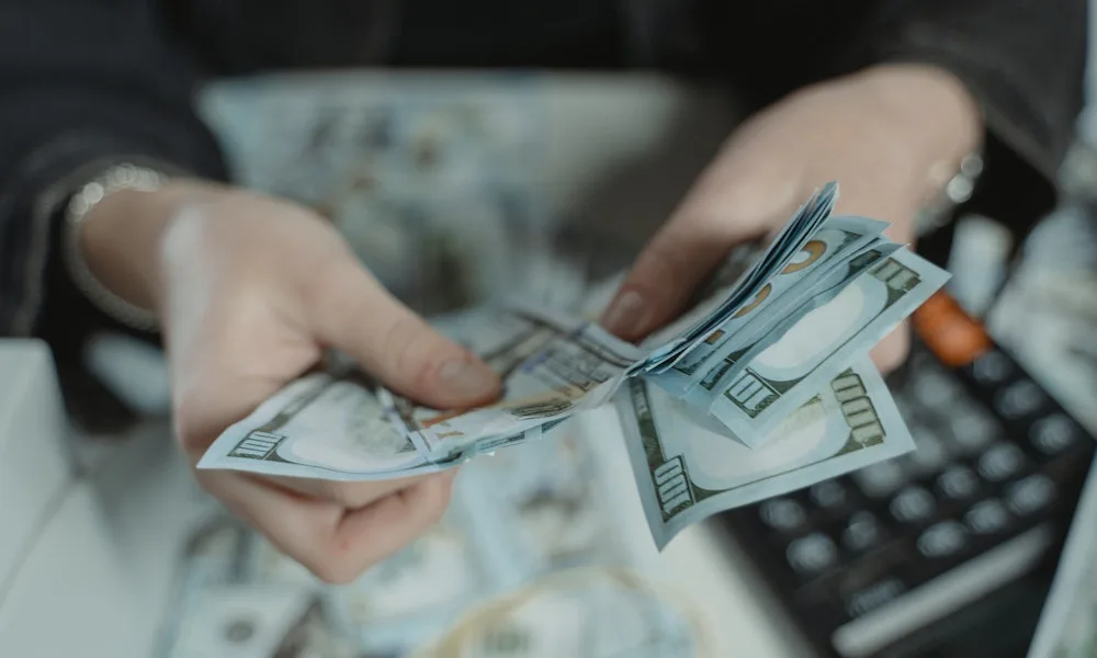 Persona contando los ingresos obtenido luego de tomar decisiones de financiamiento a corto plazo