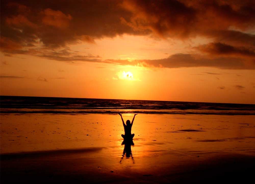 mujer realizando técnica de meditación en la playa