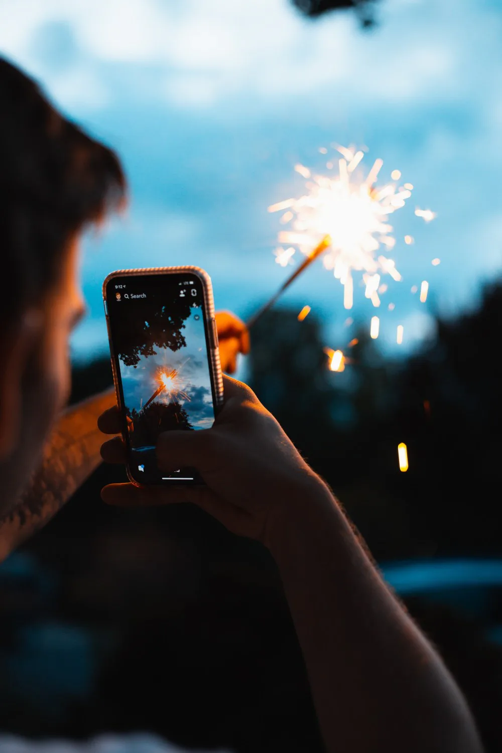 hombre tomando foto a fuego artificial