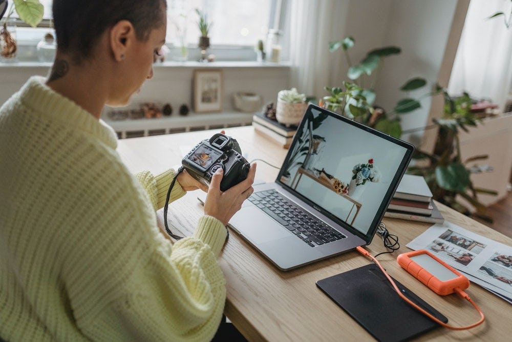 mujer mirndo fotografias en una cmara y laptop