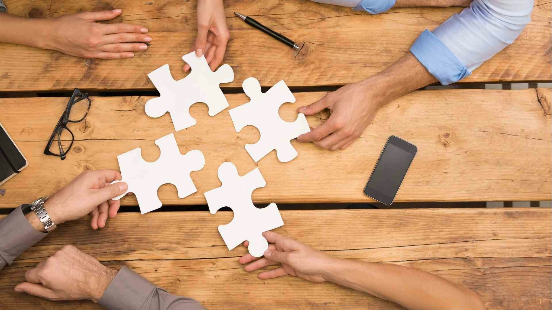 grupo personas uniendo piezas rompecabezas