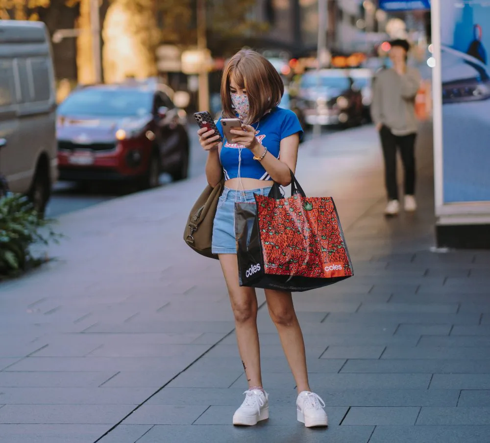 mujer en la calle viendo el celular