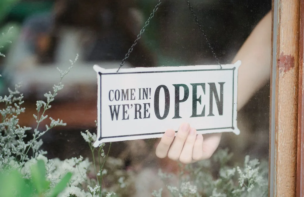 un cartel de abierto en la puerta de un local