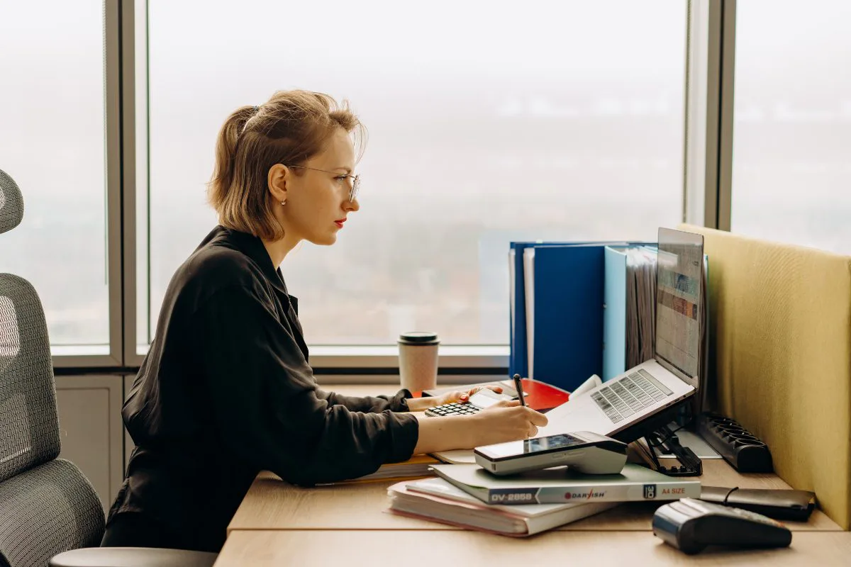 mujer ejecutiva haciendo cálculos en el computador
