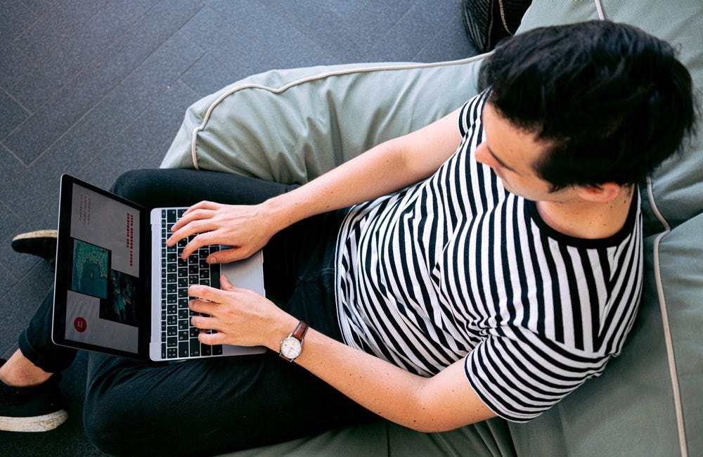 Joven diseñando en su laptop con CAD.