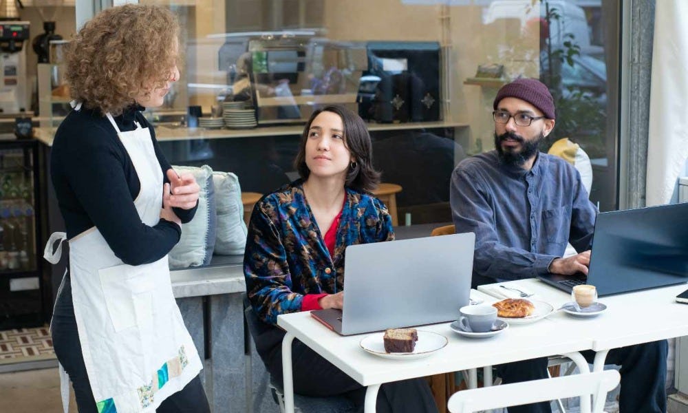 Mujer atiende a personas para mejorar lo que es una percepción del cliente