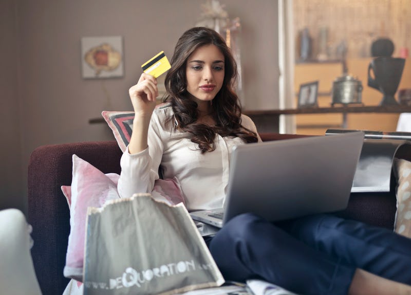 mujer sosteniendo una tarjeta de crédito para comprar online