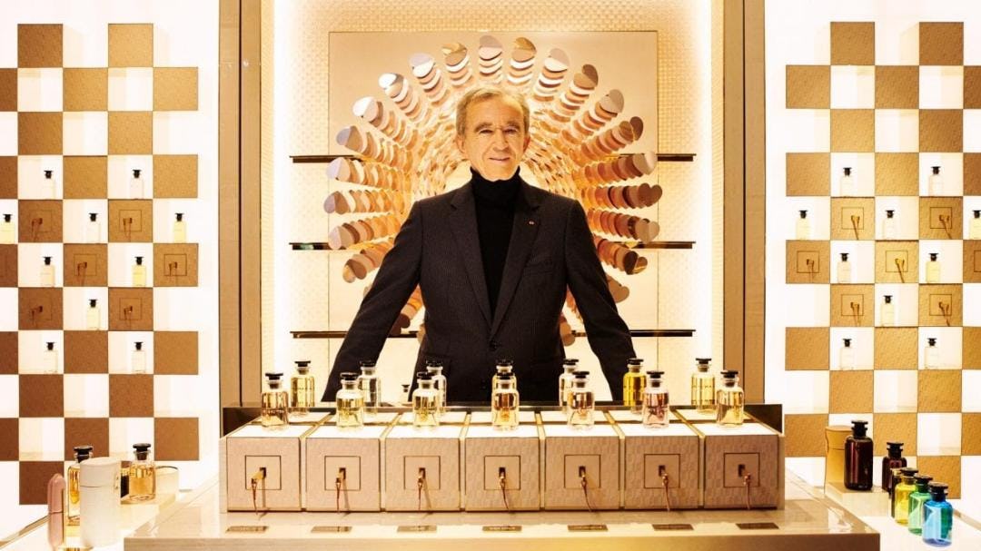 Bernard Arnault posando con sus perfumes