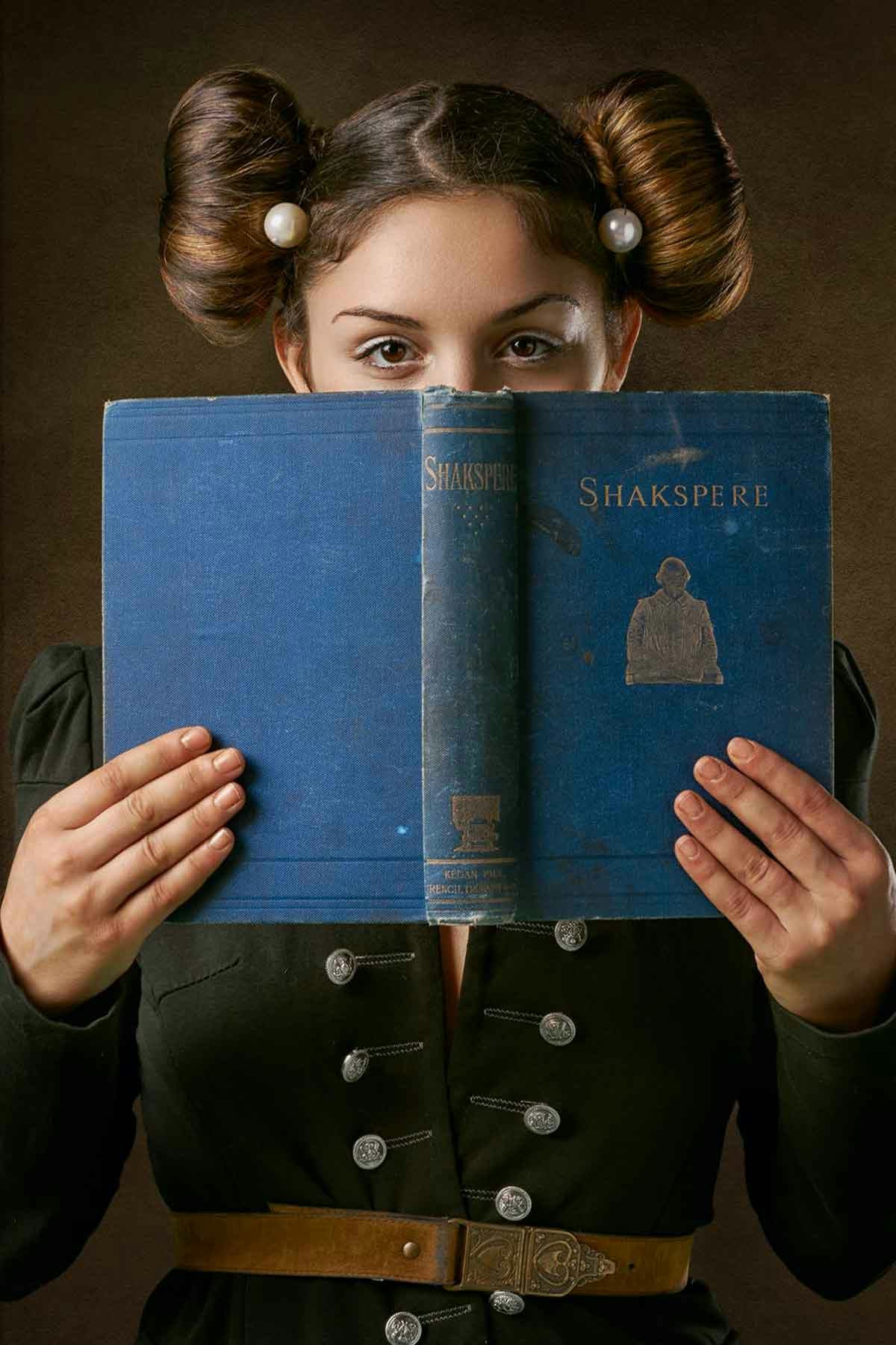 Primer plano de chica con libro de Shaekspeare