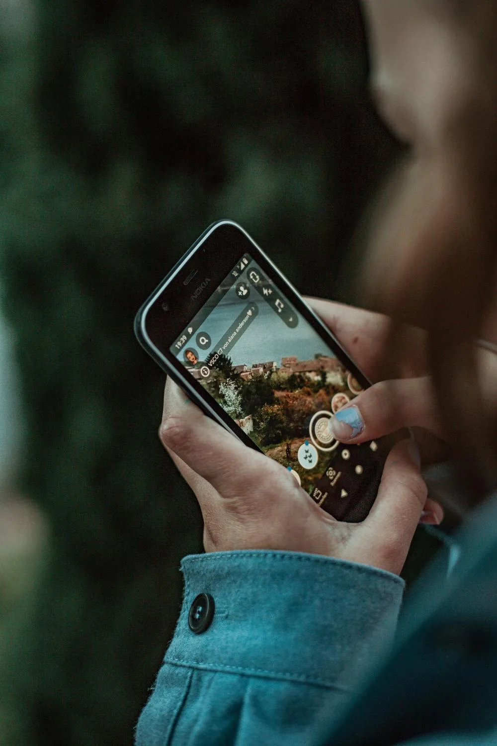 mujer tomando foto a la naturaleza con celular