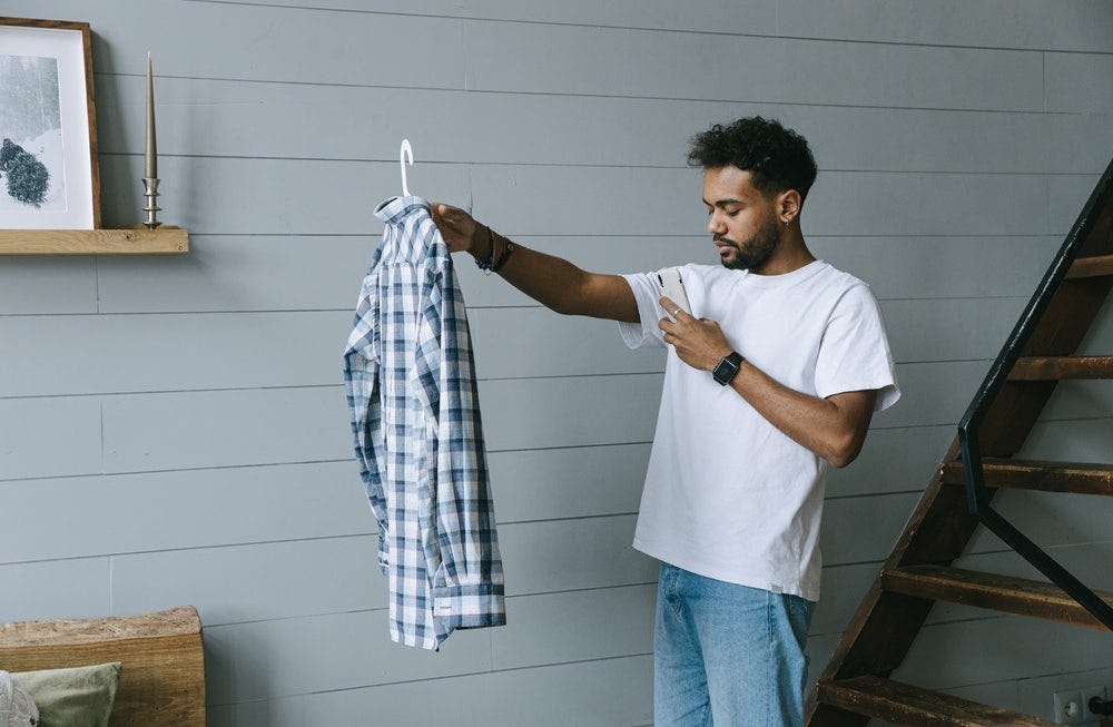 Joven tomando foto a una camisa en aplicativo de Visual Search
