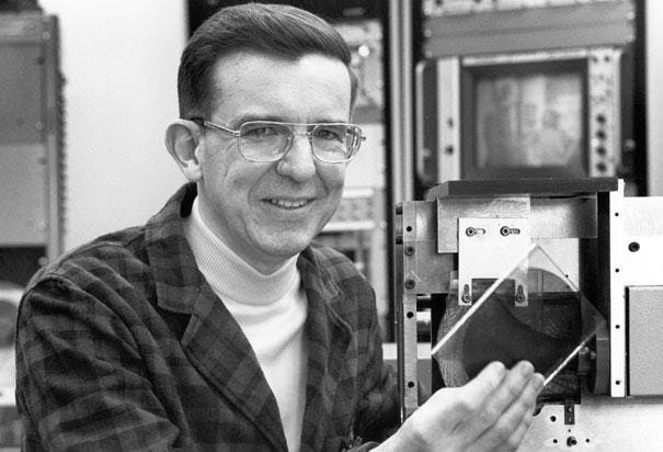 James T Russel sosteniendo un disco óptico