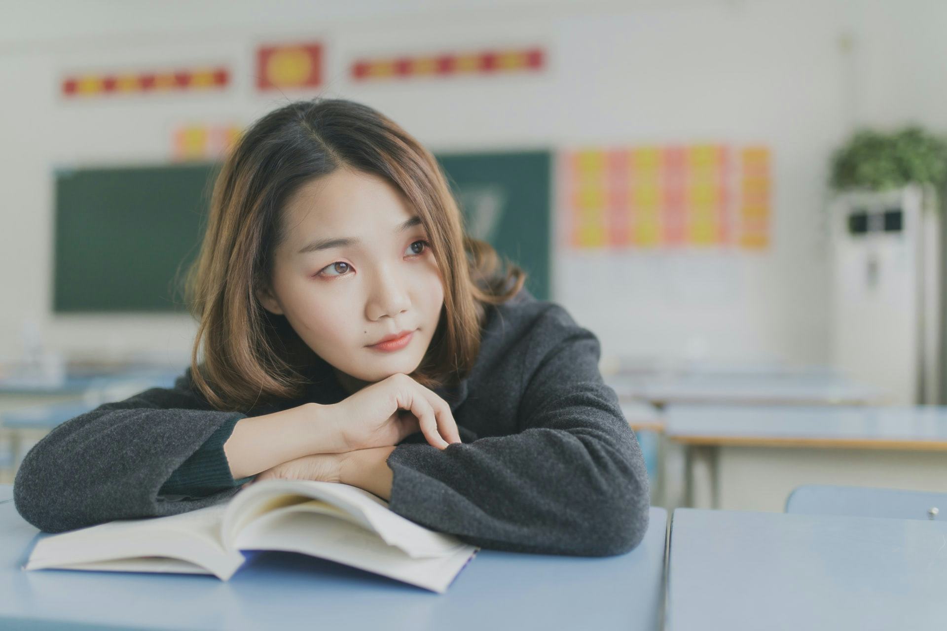 Joven mujer reflexiona con libro