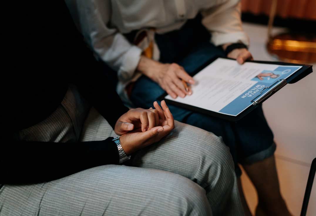 personas en entrevista de trabajo mostrando su currículum creativo