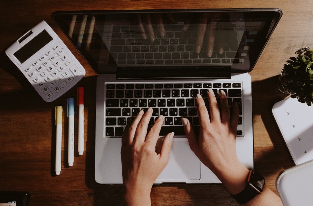 persona frente a una computadora personal con calculadora