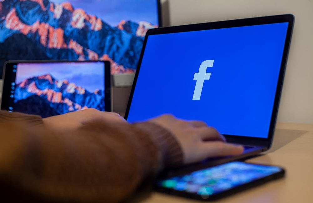 un monitor proyecta el logo de facebook