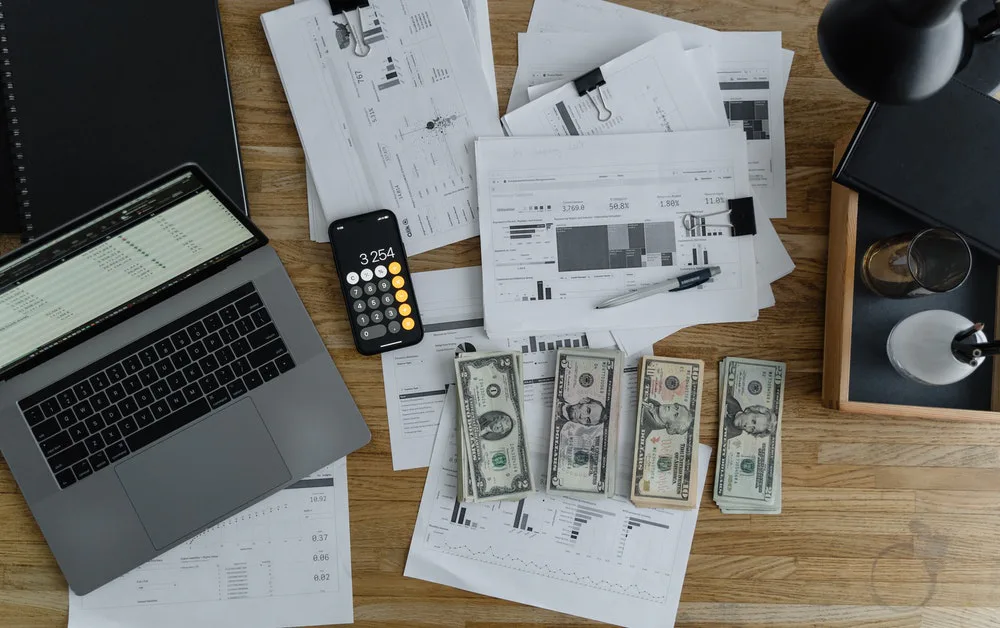 Fotografía de muchos dolares, latop y papeles para la organización de inversión económica.