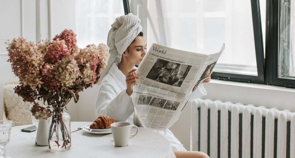 mujer leyendo un periódico en la mañana