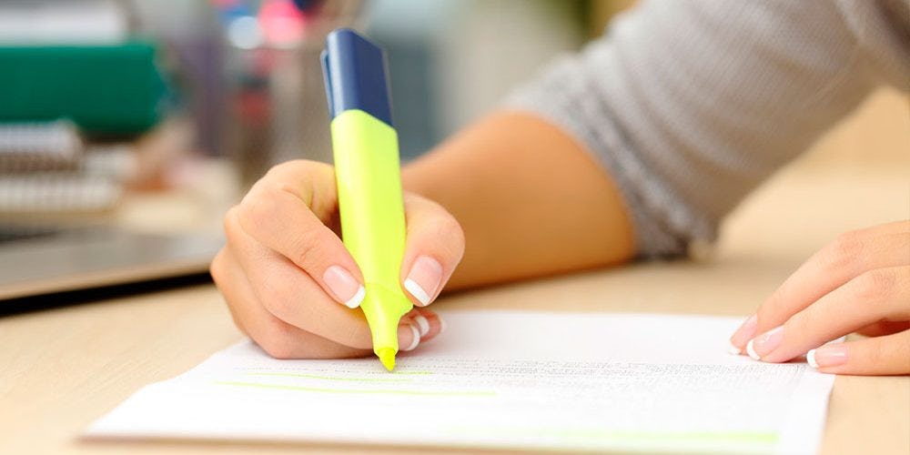 persona resaltando ideas principales para hacer un resumen creativo