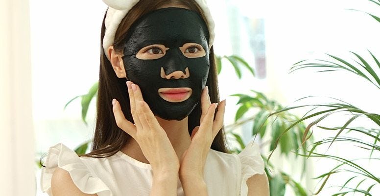 mujer usando mascarillas faciales de carbón