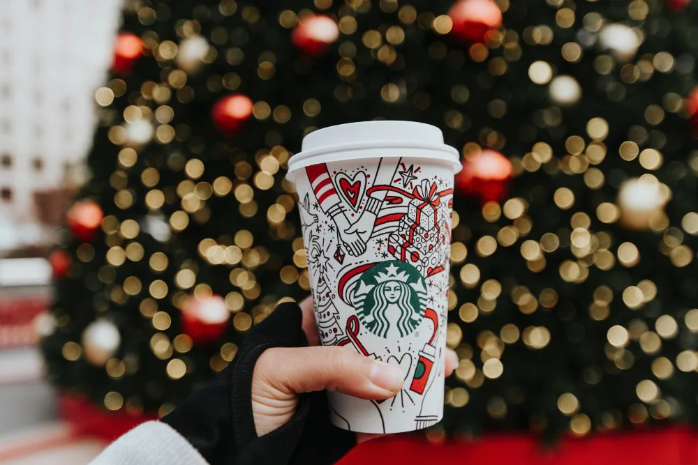 mano cogiendo vaso de Starbucks en navidad