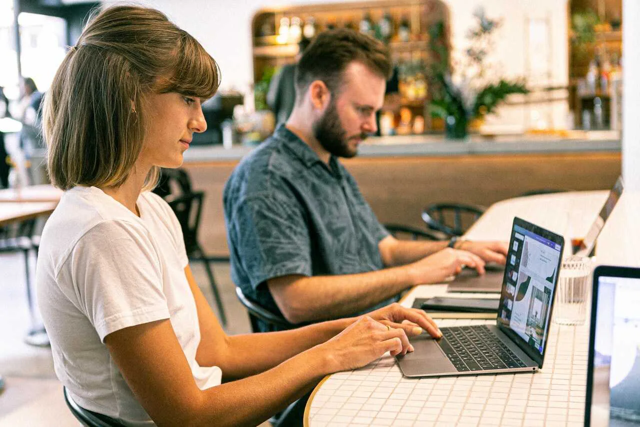 dos cofundadores trabajan en sus laptops en una mesa de trabajo