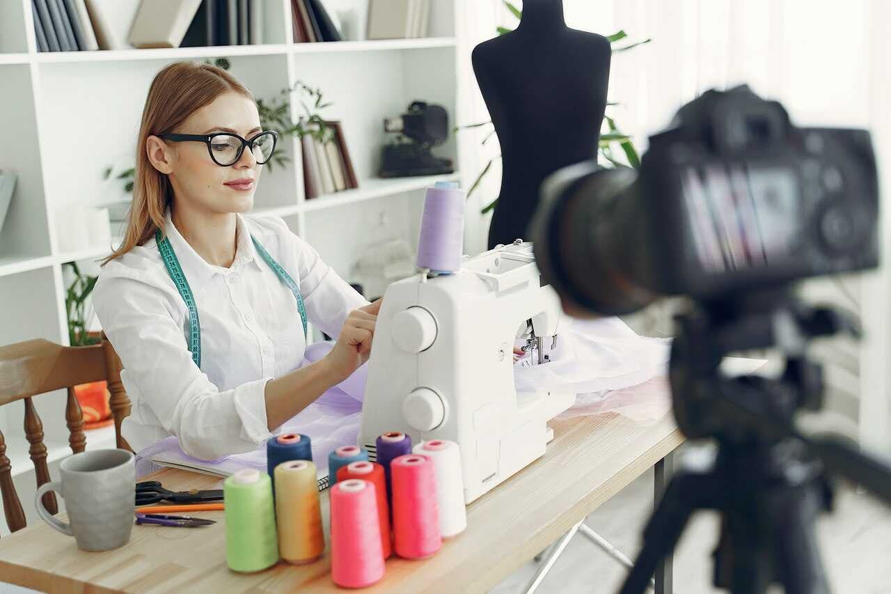 emprendedora de ropa trabaja en sus diseños en una mesa con sus herramientas