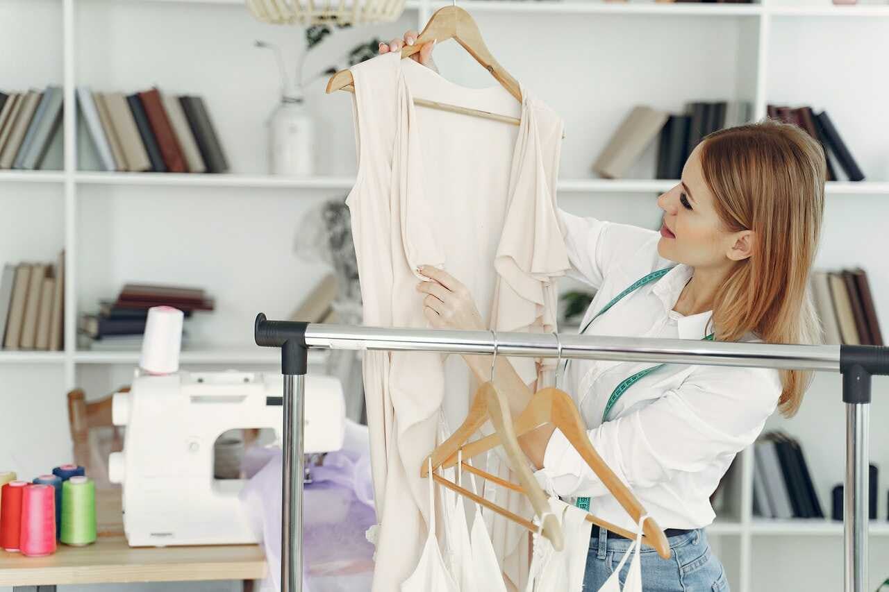 diseñadora de ropa observa sus prendas en su taller