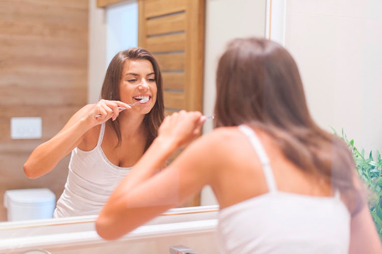 Mujer lavándose los dientes como hábito