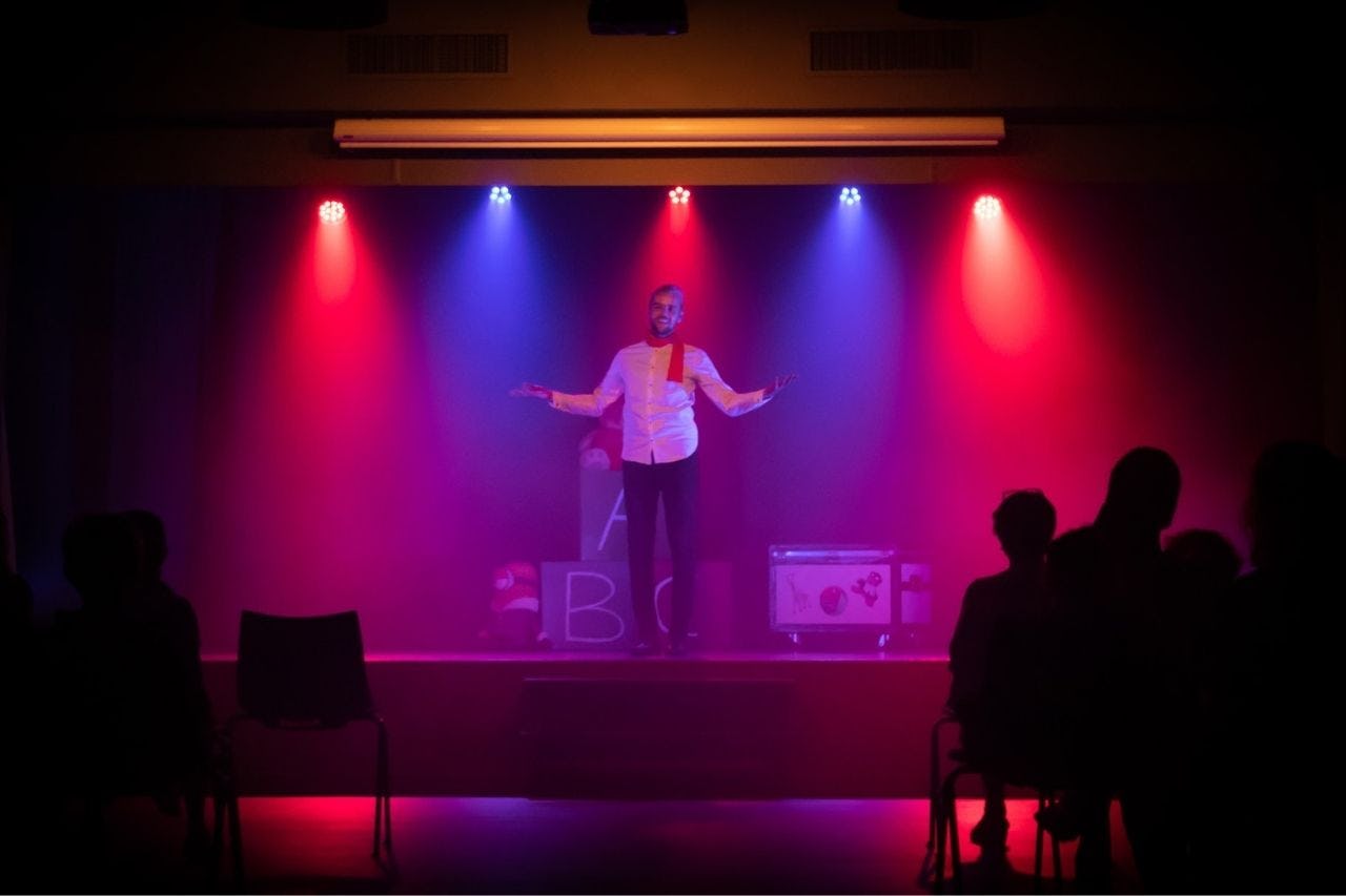 hombre haciendo stand up en un escenario frente al público