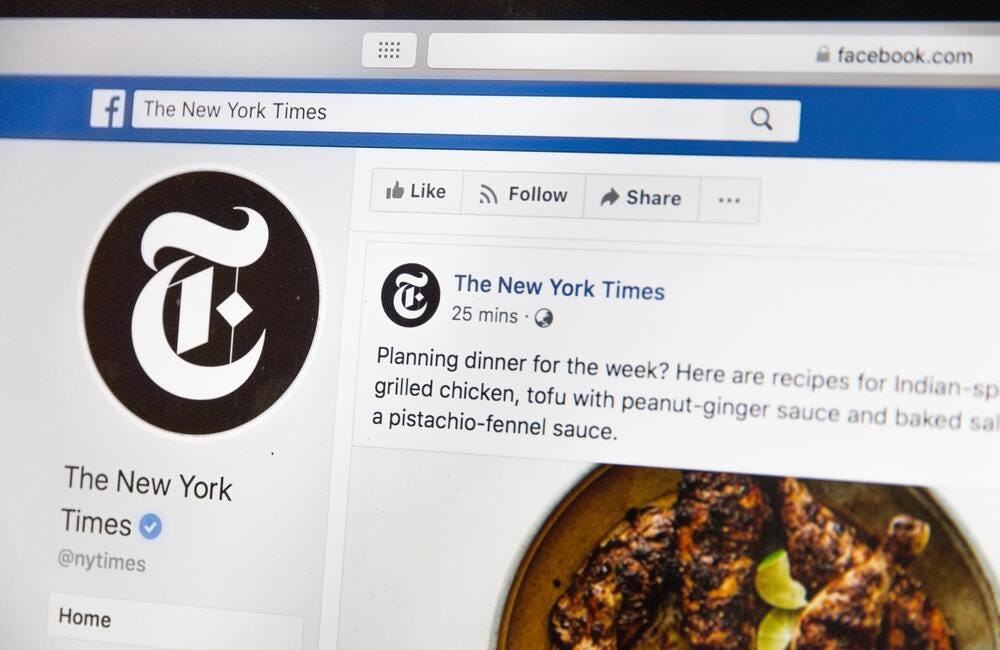 una pantalla proyecta la página del new york times en facebook 