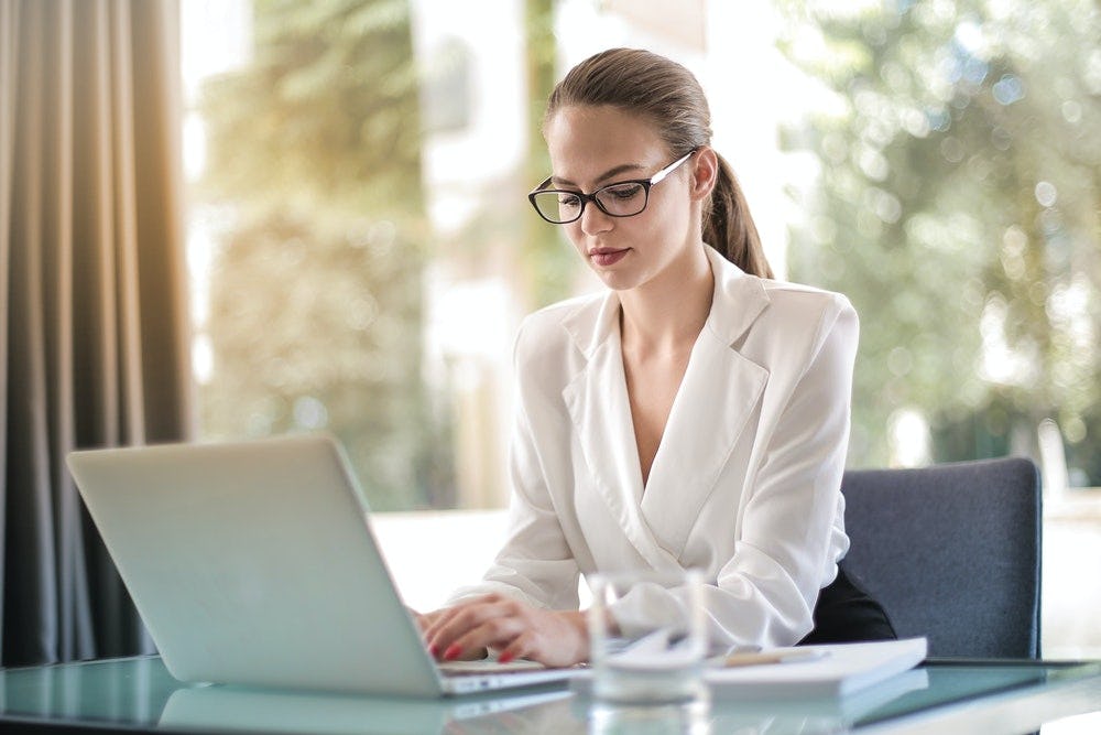 mujer con gafas profesional trabajando en una computadora