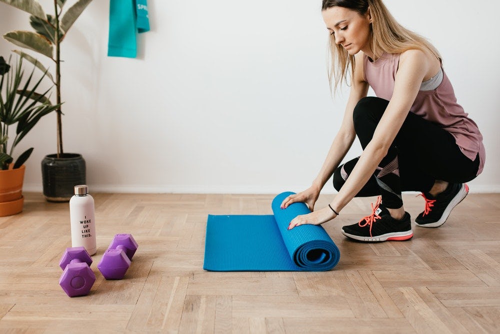 mujer preparando su área de entrenamiento desde casa