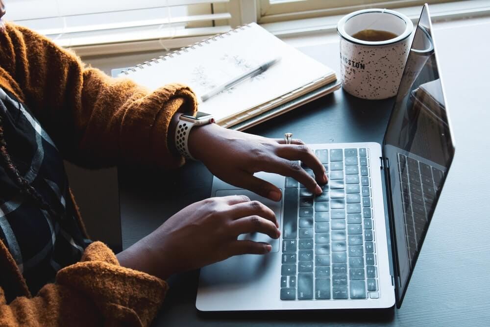 mujer escribiendo en laptop
