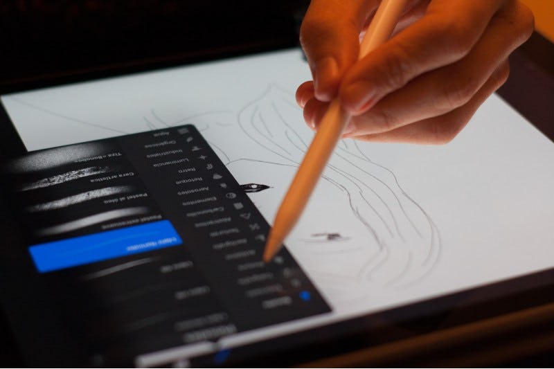 Persona dibuja rostro en tablet digital