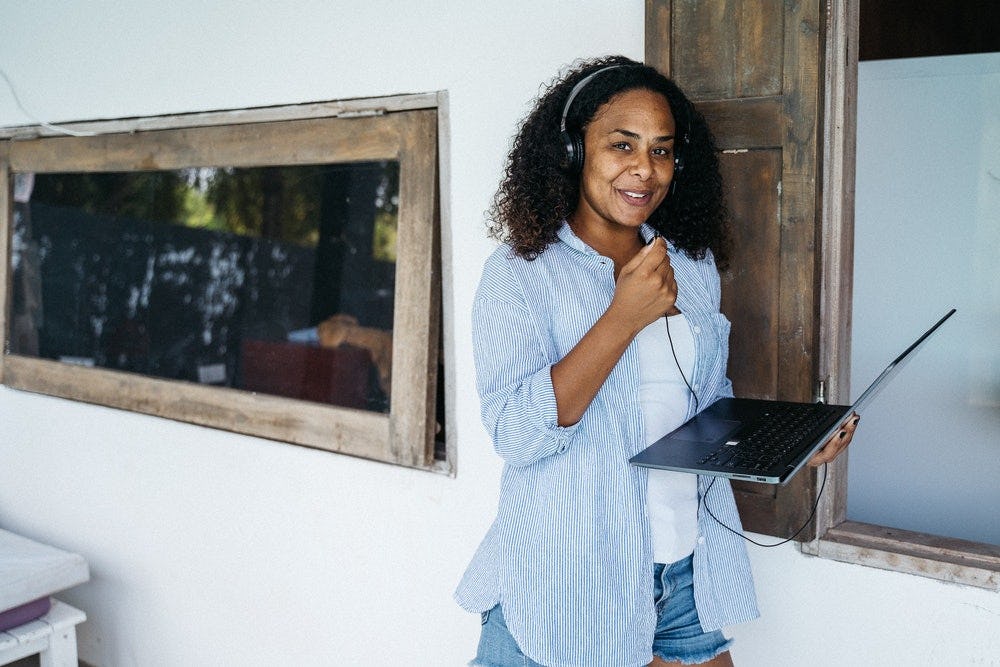 mujer grabando su voz en una computadora con ayuda de auriculares