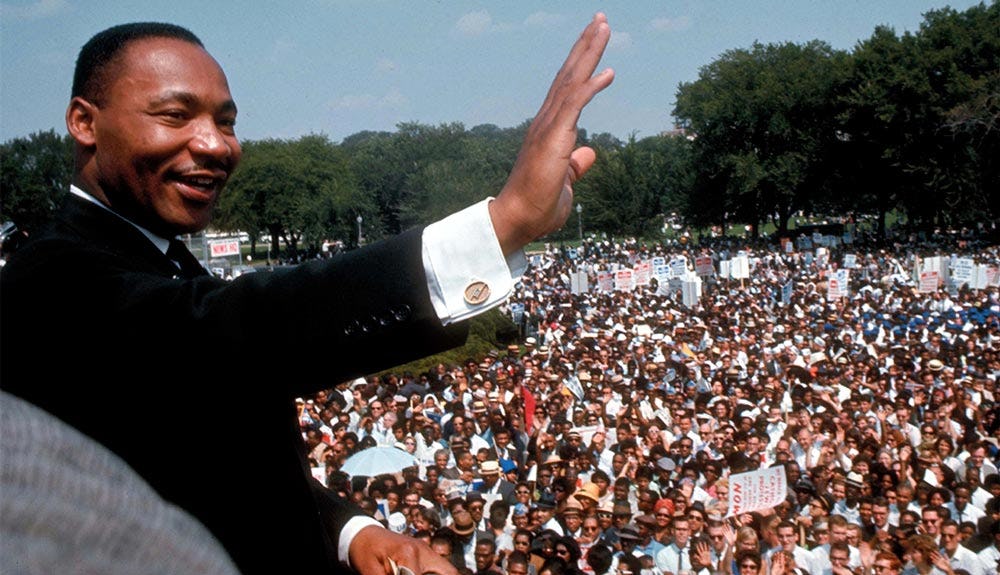 Martin Luther King Jr. saludando a la multitud