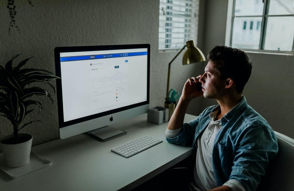 un hombre visualiza su cuenta de facebook en la pantalla de su computador