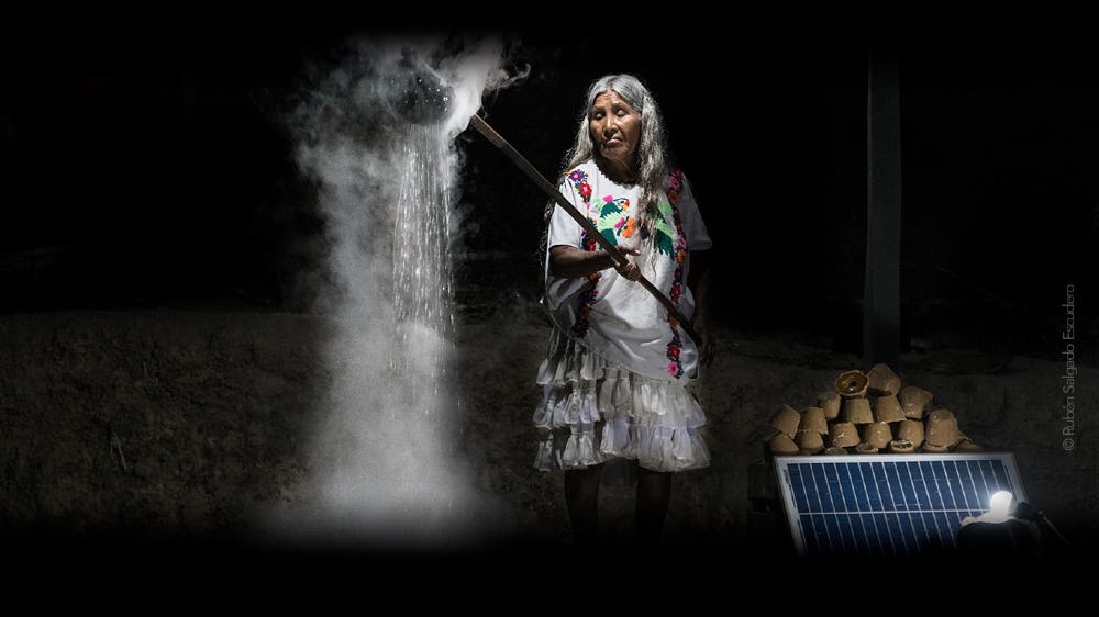 mujer usa paneles solares del proyecto emprendedor IluMexico