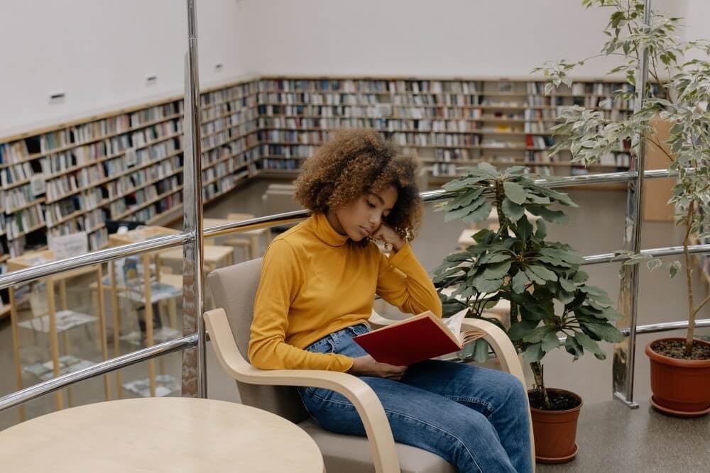 niña leyendo un libro en biblioteca