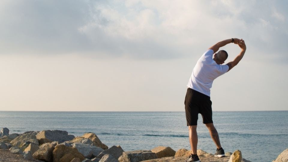 hombre haciendo ejercicios frente al mar